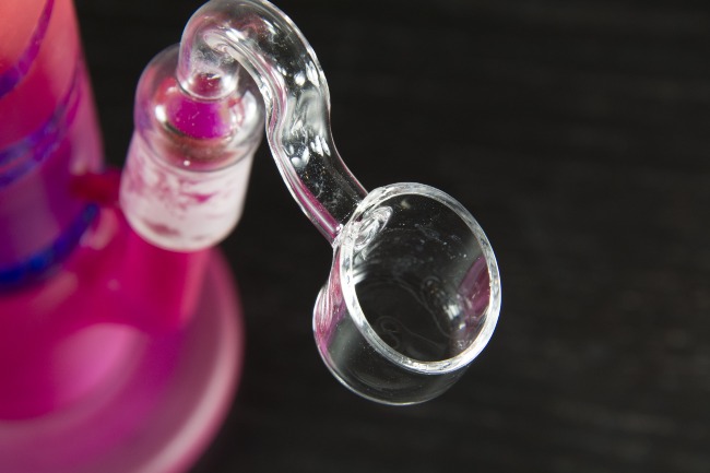 Up close image of a glass banger attached to a pink bong