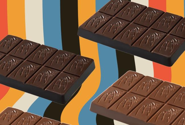 Chocolate bars floating in front of a background that has waving retro colors of black, orange, blue, beige, and yellow.