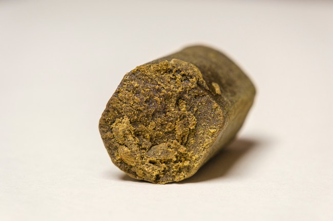 dark colored cannabis hash log that is in a cylindrical shape. 