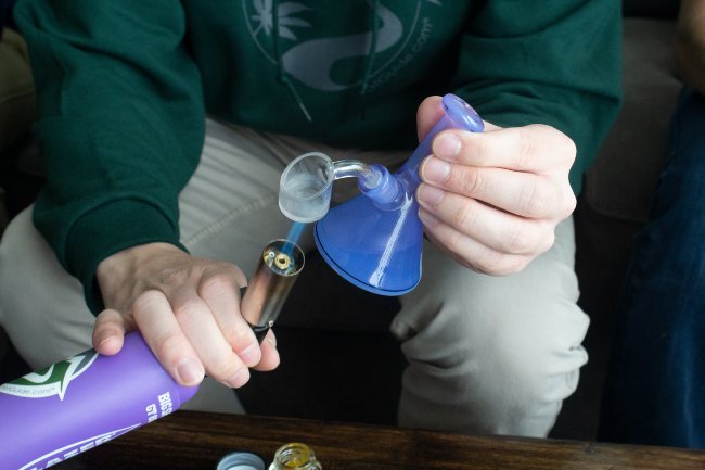 purple torch heating a clear glass banger and bong