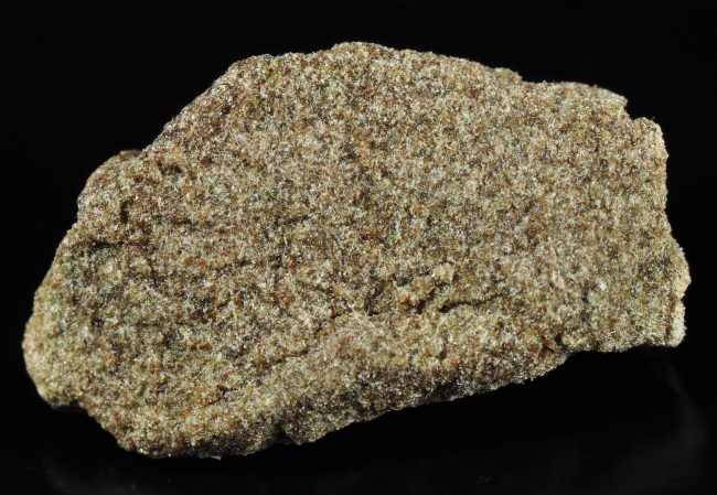 close up image of green and brown brick of bubble hash